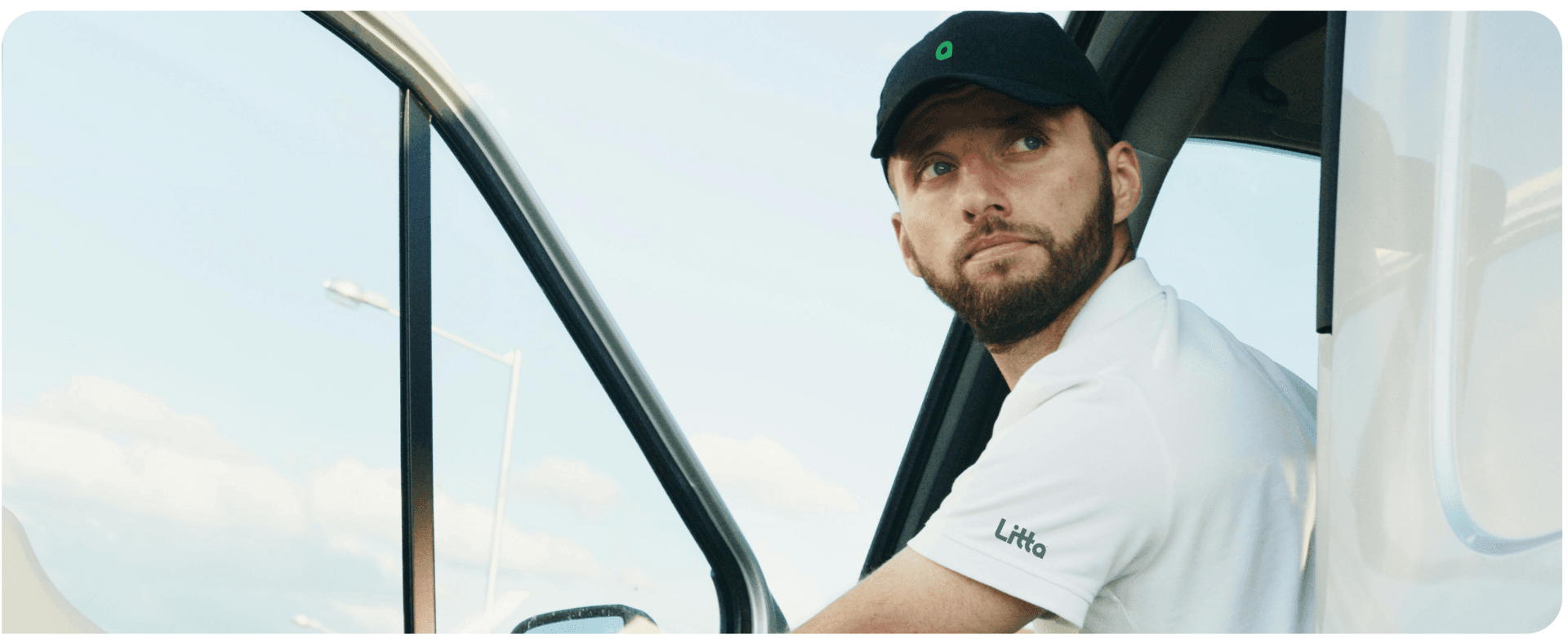 Professional Litta waste collection driver in branded uniform standing next to company vehicle